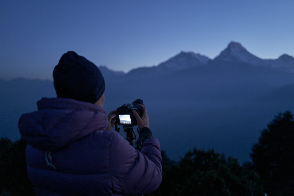 Photo d'une personne prenant en photo des montagnes des Annapurnas